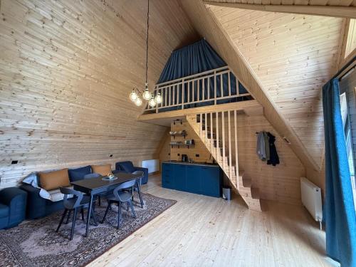 a room with a table and chairs and a staircase at Casa KamArea in Stepantsminda
