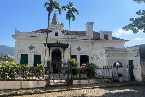 里约热内卢Castelo dos Tucanos Host的前面有棕榈树的白色教堂