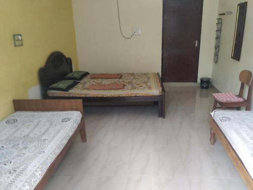 a room with two beds and two chairs at Holiyday in VGF Farm House in Dānishpet