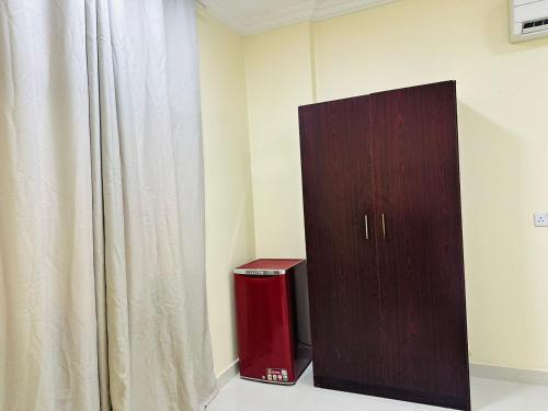 a room with a wooden cabinet next to a curtain at العربي للشقق المفروشة in Salalah