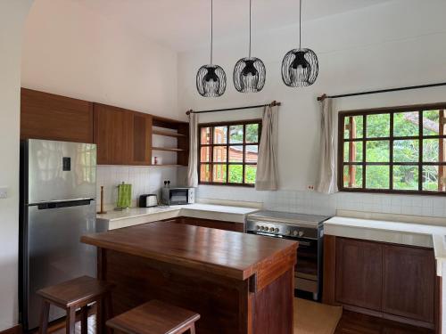 a kitchen with wooden cabinets and a wooden table at Madarisha House in Kilifi