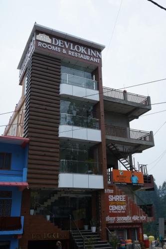 a building with a sign for a hotel at Devlok Inn in Lohaghāt