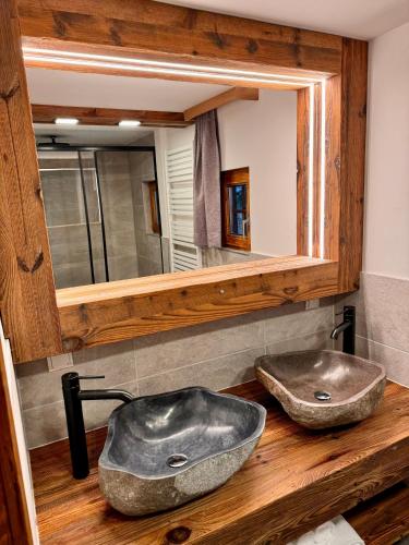 a bathroom with two sinks and a mirror at Das Alpl Resort in Krieglach