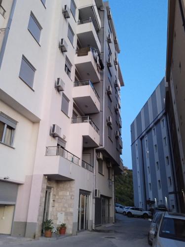 an apartment building with balconies and a parking lot at Apartman Martina 3 in Rafailovici