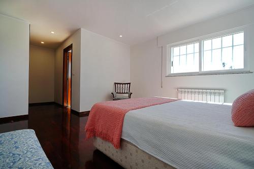 Un dormitorio con una cama grande con una manta roja. en Casa con jardín en Fefiñanes, Cambados, en Cambados