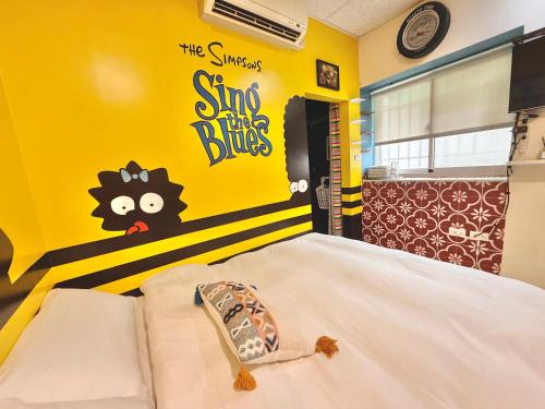 a bed in a room with a yellow wall at 斑比Bambi in Tainan