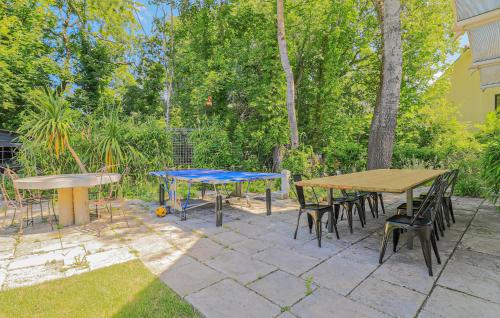 a patio with two tables and chairs and trees at Spacieuse Maison De Ville in Étaples