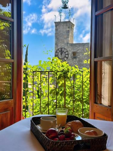 Una bandeja de comida en una mesa frente a una ventana. en Hostellerie Le Beffroi, en Vaison-la-Romaine