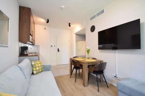 a living room with a table and a couch at Shellter Rogowo 117J Apartamenty przy Morzu ATK in Rogowo