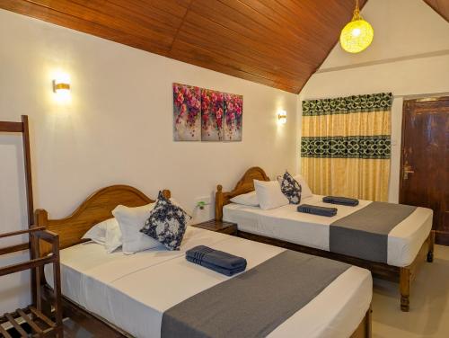 two beds in a room with at Sigiri Choona Lodge 'unique sunrise viewpoint' in Sigiriya