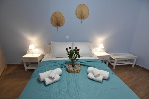 a bedroom with a bed with towels and flowers on it at Charavgi House in Archangelos