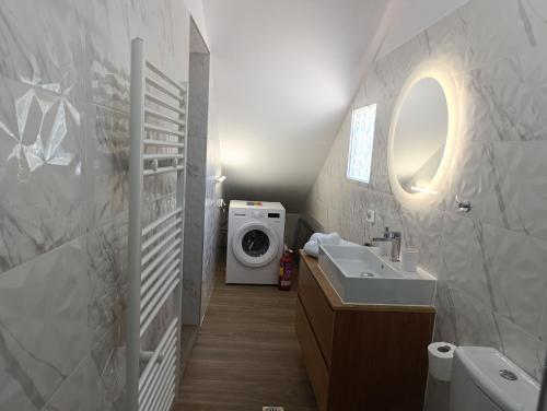 a bathroom with a sink and a washing machine at Charavgi House in Archangelos