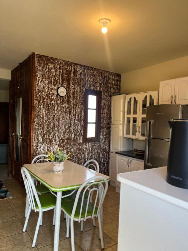 una cucina con tavolo, sedie e frigorifero di Apartamento amplo 300m da praia a São Lourenço do Sul