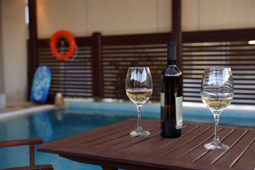 a bottle of wine and two wine glasses on a table at Rafina Splendor in Rafina