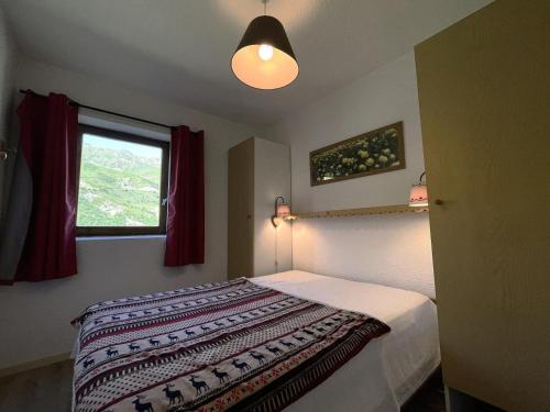 une chambre avec un lit et une fenêtre dans l'établissement Résidence Jetay - Appartement 4 personnes aux Ménuires MAE-5144, aux Menuires