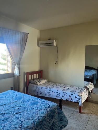 una camera da letto con due letti e uno specchio di Apartamento amplo 300m da praia a São Lourenço do Sul