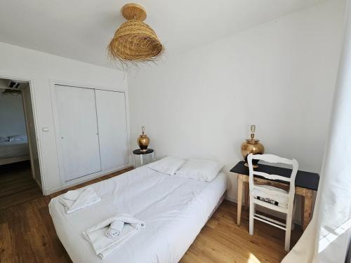 a bedroom with a white bed and a chair at Appartement trois chambres avec jardin in Montboucher-sur-Jabron