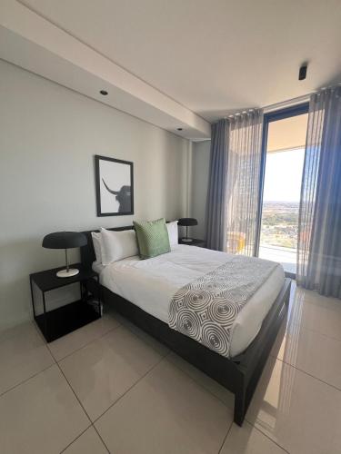 a bedroom with a bed and a large window at Kabazela at Ellipse in Midrand