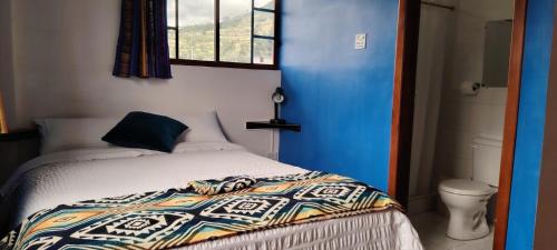a bedroom with a bed and a window at Green House Araque Inn in Otavalo