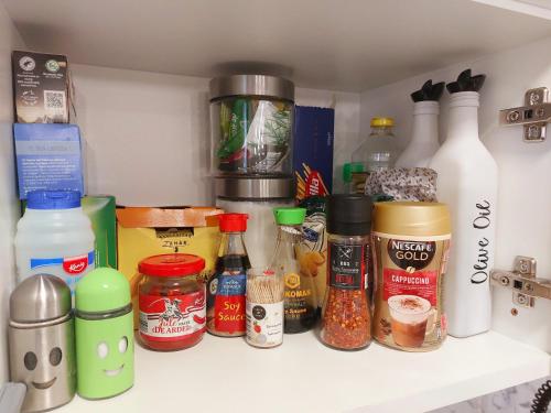 a shelf filled with lots of different types of condiments at Cozy Cube - tiny house in Şarul Dornei