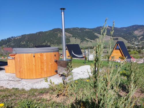 a group of small wooden houses in a field at Cozy Cube - tiny house in Şarul Dornei