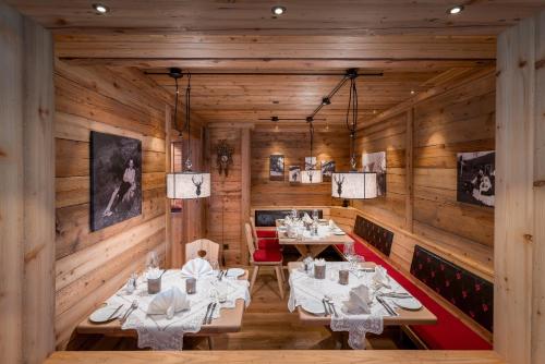 a restaurant with wooden walls and tables and chairs at Naturparkhotel Adler in Wolfach