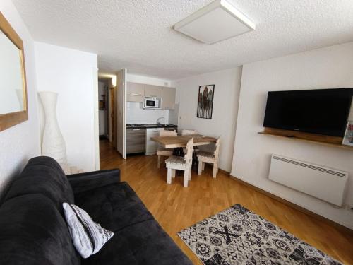 un salon avec un canapé noir et une table dans l'établissement Résidence Chalmettes - Joli studio rénové avec accès direct aux pistes. parking privé. MAE-8704, à Montgenèvre