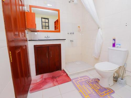 a bathroom with a toilet and a mirror at N1 house St Helen lane Karen in Nairobi