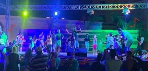 Une foule de gens qui regardent un spectacle sur une scène dans l'établissement Aqua View, à El Qasaba esh Sharqīya