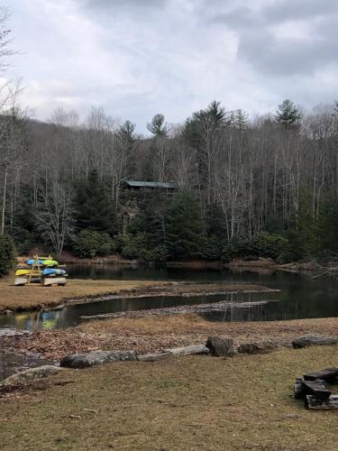 a pond with a yellow boat in the middle at Beech Mountain Swiss-style Chalet in Beech Mountain