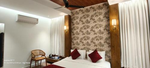 a bedroom with a bed with red pillows at Indudharam Tourist Home - Vaikom Temple in Vaikom