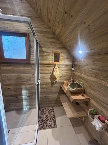 a bathroom in a log cabin with a sink at Aos Pés do Gigante in Joanópolis