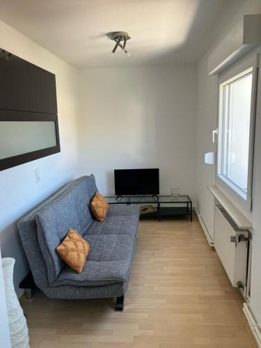 a living room with a blue couch and a tv at Apartment in Osnabrück in Osnabrück