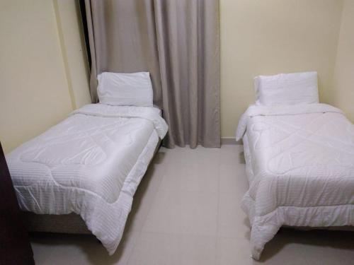 two beds sitting next to each other in a room at العربي للشقق المفروشة in Salalah