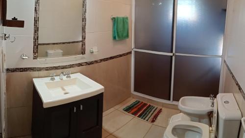 a bathroom with a sink and a toilet at Hospedaje Las Canelas in Wanda