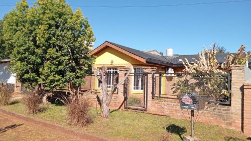a brick house with a tree in the yard at Hospedaje Las Canelas in Wanda