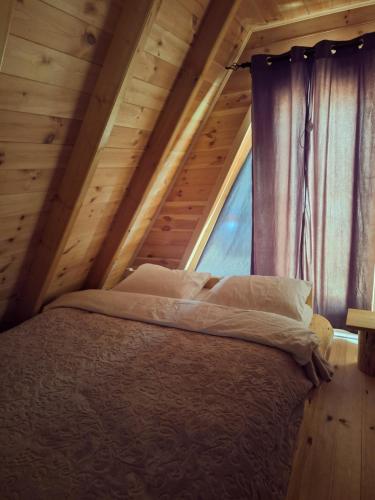a bed in a room with a window at Chalets Montenegrina in Žabljak