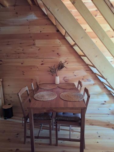 a wooden table and chairs in a attic at Chalets Montenegrina in Žabljak