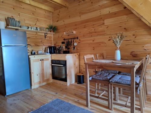 a kitchen with a table and a refrigerator at Chalets Montenegrina in Žabljak