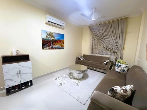 a living room with a couch and a tv at العربي للشقق المفروشة in Salalah
