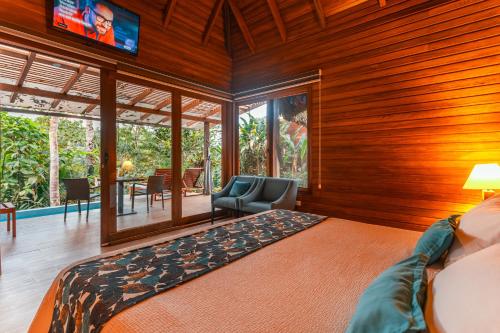 a bedroom with a bed and a tv in a room at El Jardin Lodge & Spa in Puerto Misahuallí