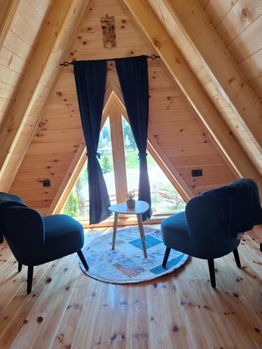 a room in a cabin with two chairs and a table at Chalets Montenegrina in Žabljak