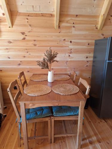 a dining room table with chairs and a refrigerator at Chalets Montenegrina in Žabljak