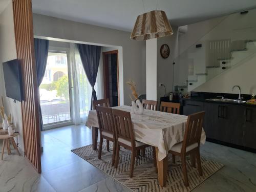 une cuisine et une salle à manger avec une table et des chaises dans l'établissement Charming Twin House In Paros - Mountain View Ras ElHikma - North Coast Egypt, à Ras Elhekma