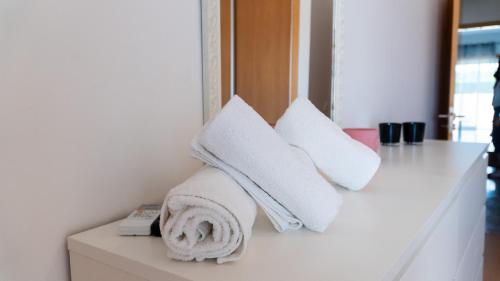 una pila de toallas sentadas en un mostrador en una habitación en Pandora House, en Nazaré