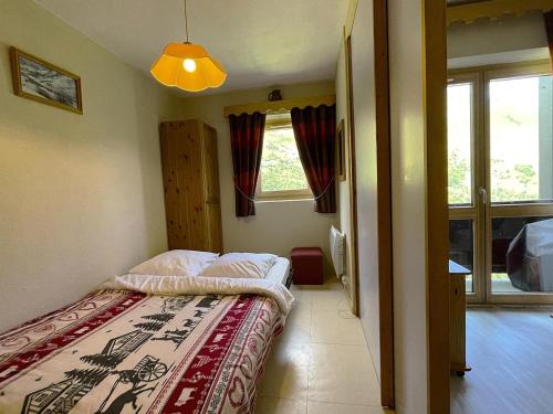 une petite chambre avec un lit et une fenêtre dans l'établissement Résidence Jetay - Appartement 4 personnes avec vue sur la montagne MAE-5604, aux Menuires