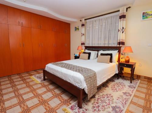 a bedroom with a large bed with wooden cabinets at St Helen lane Karen in Nairobi