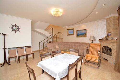 a living room with a couch and a table and chairs at Blue Panorama Sevan in Sevan