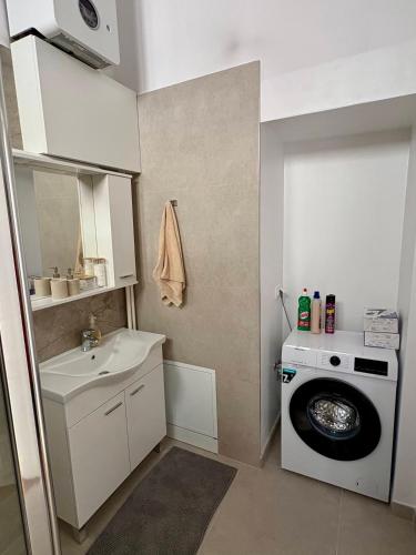 a small bathroom with a washing machine and a sink at La Perla Centre in Zagreb