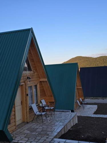 a couple of buildings with chairs and a table at Summit chalets TL in Žabljak